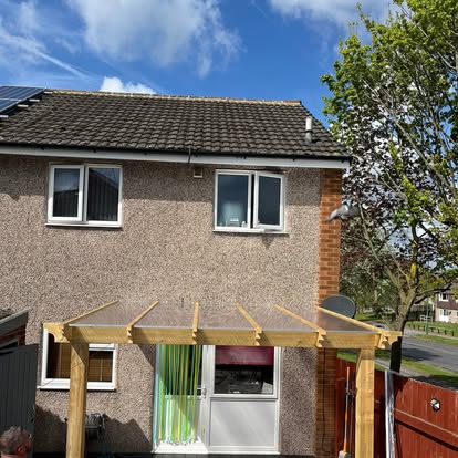 House exterior with polycarbonate pergola and decking