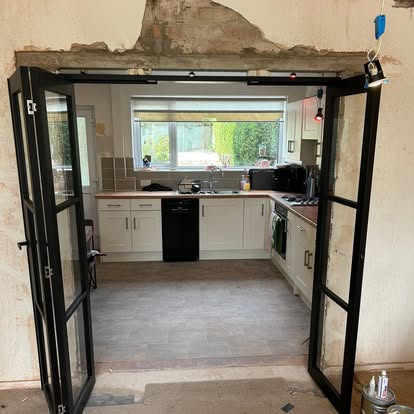 Black glazed internal doors open to kitchen