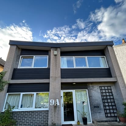 House 9A with dark cladding and flat roof