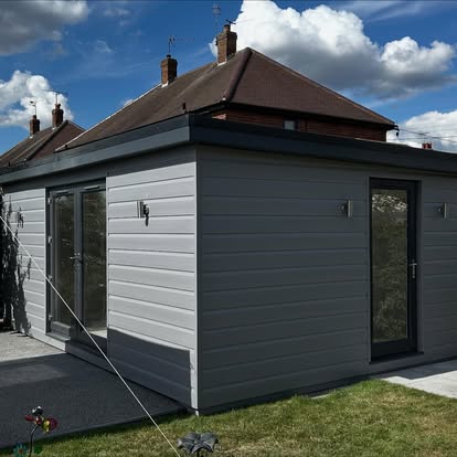Grey-clad garden room side view with sliding door