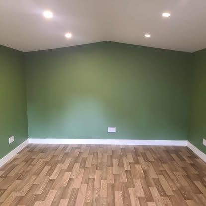 Garden room interior with green walls, wood floor