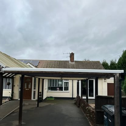 Bungalow with dark steel polycarbonate carport