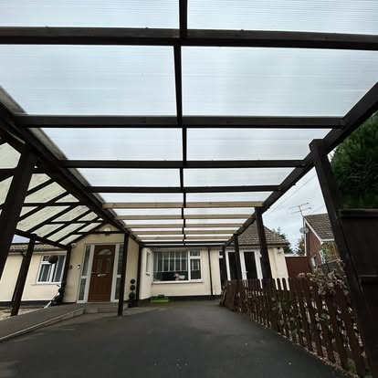 Completed dark steel carport with polycarbonate roof