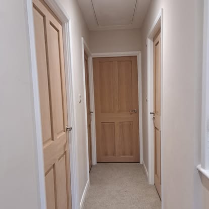 Oak 4-panel doors in hallway, carpet floor