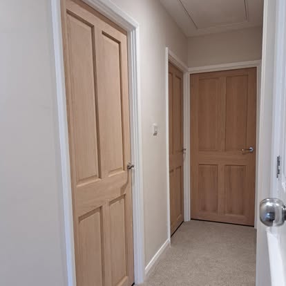Oak 4-panel doors in hallway with carpet floor