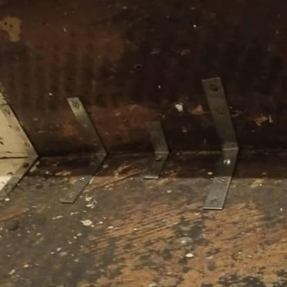 Metal angle brackets fitted to old stair tread