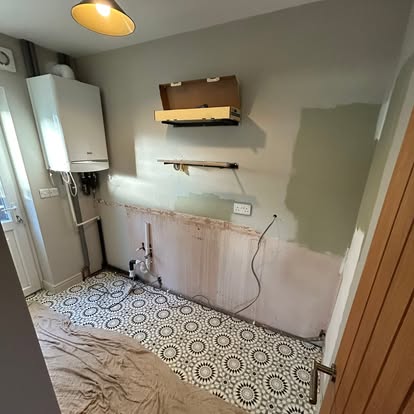 Utility room mid-install, navy units and patterned tiles