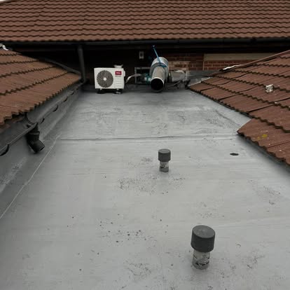 New grey flat roof between two pitched tile roofs