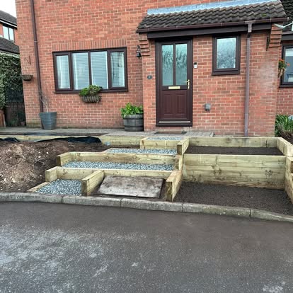 Timber sleeper raised beds being built in front garden