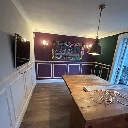 Purple dining room with wall panelling and dining table