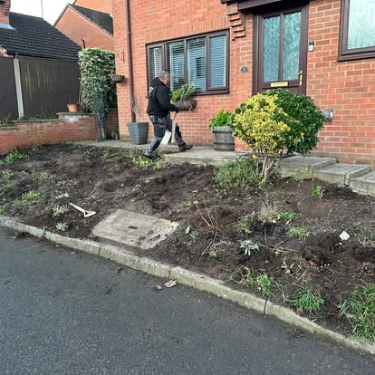 Worker clearing front garden before landscaping