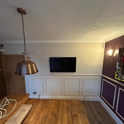 White wall panelling with TV mounted, purple room